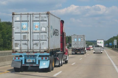 Vrachtwagens met containers op een snelweg